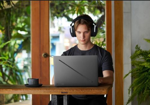 Foto de un hombre jóven y serio mirando un computador de Asus