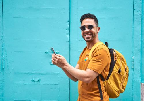 Foto de un joven sonriendo a la camara con camiseta amarilla