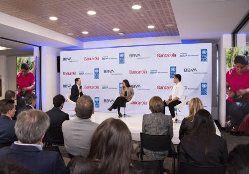 Foto de un panel con tres personas sentadas conversando Bancamía