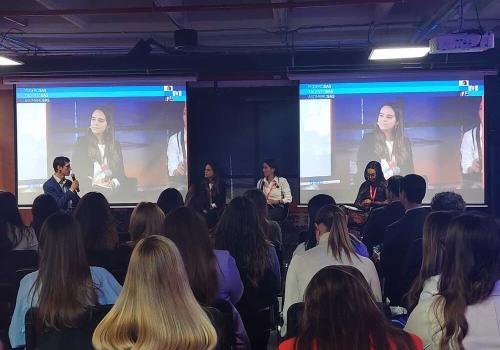 Foto de un salón lleno de personas con mujeres panelistas