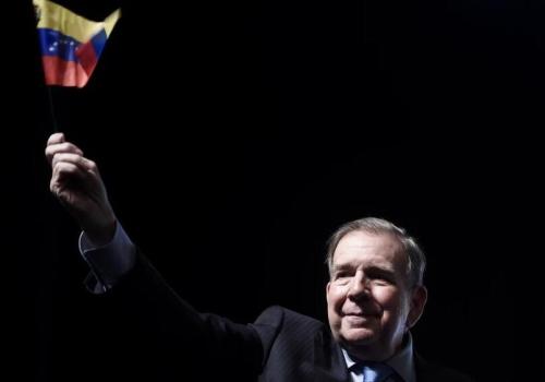 Foto de un señor con la bandera de venezuela en la mano derecha