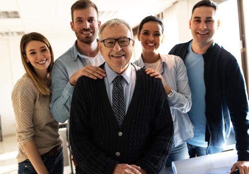 Foto de un señor con varias personas de fondo