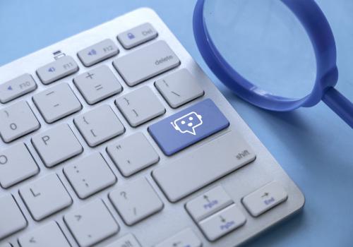 Foto de un teclado blanco con una tecla azul que simula un pc