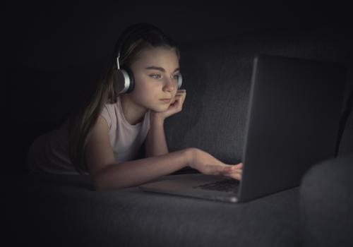 Foto de una chica mirando la computadora en la noche