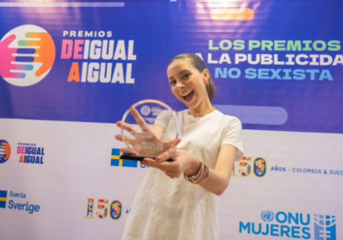 Foto de una mujer con un premio en sus manos 