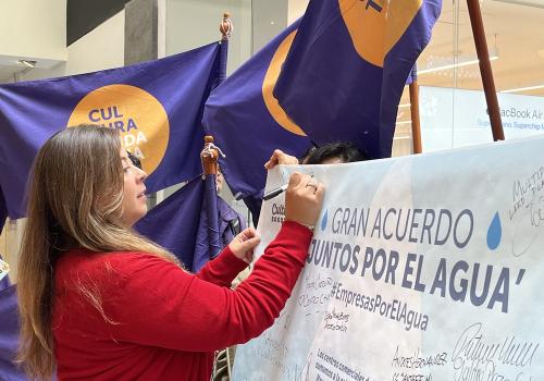 Foto de una mujer firmando un acuerdo con la mano