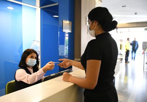 Foto de una mujer pagando un servicio en una eps