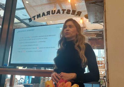 Foto de una mujer presentando frente a un televisor