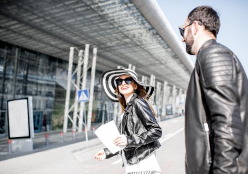 Foto de una pareja con chaqueta negra entrando a un aeropuerto