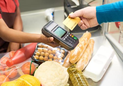 Foto de una persona comprando con una tarjeta mediante un datafono