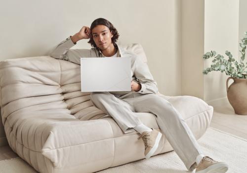 Foto de una persona con una computadora asus blanca sobre un sofa