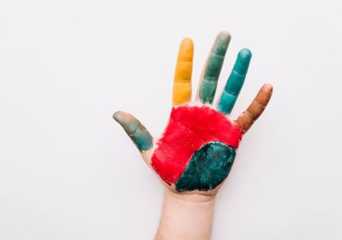 Foto de una persona con una mano pintadas de varios colores