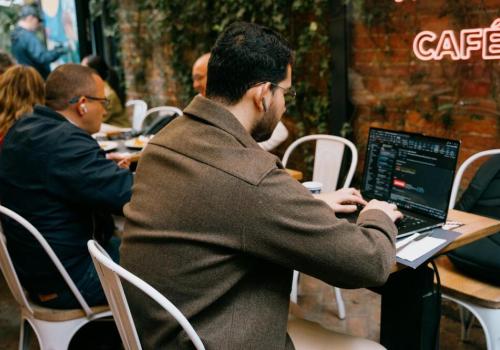 Foto de una persona de espaldas escribiendo sobre un computador