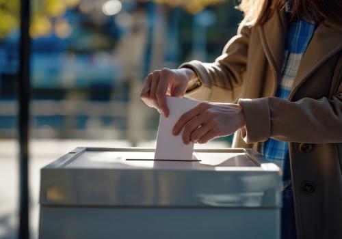 Foto de una persona depositando una hoja en una caja