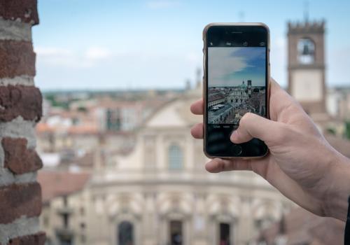 Foto de una persona tomando una fotografia con el celular y el fondo de una ciudad europea