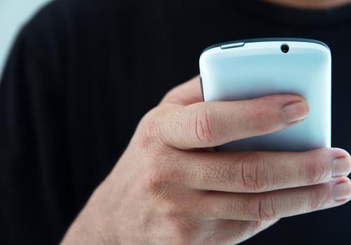 Foto de una persona utilizando un teléfono de color azul aguamarina