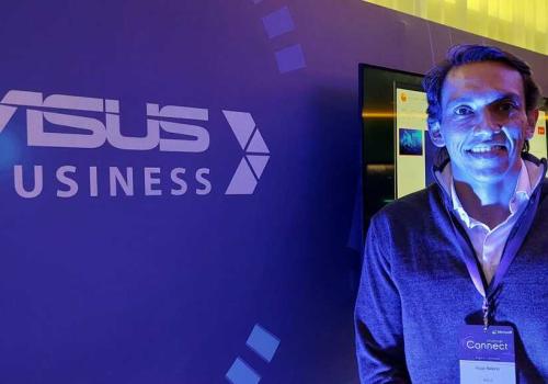 Foto de una personas mirando a la cámara, plano medio, con luz morada y de fondo dice Asus Business