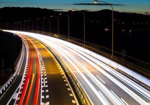 Foto de una vía con efecto de cámara, los carros se ven como luces de varios colores