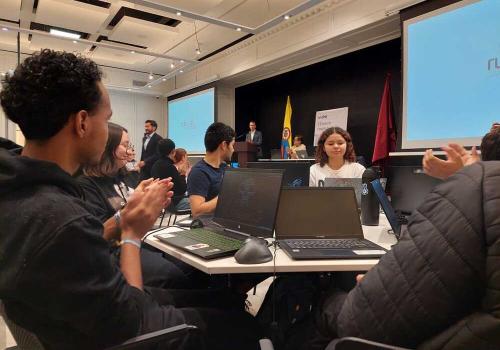 Foto de varias jóvenes sentados en una mesa mirando el computador