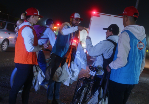 Foto de varias personas entregando kits en la calle