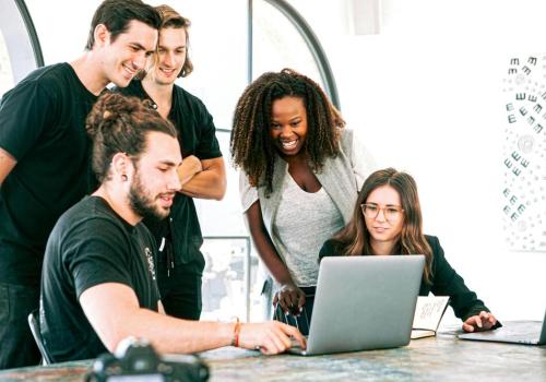 Foto de varias personas reunidas frente a un computador