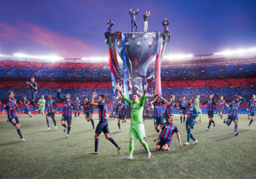 Foto del barcelona celebrando con una copa gigante de fondo