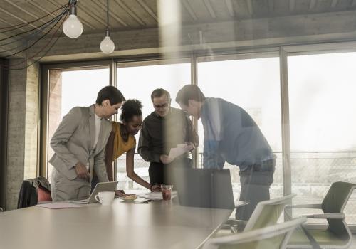 Fotografia de un equipo de trabajo hablando sobre una mesa