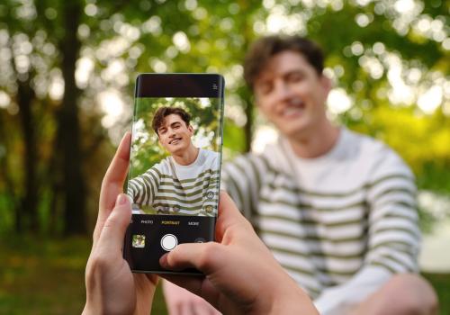 Fotografia de una persona dentro del encuadre del celular con fondo verde