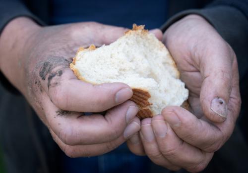 Imagen de una persona con un pan en la mano.