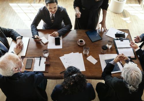 Una foto cenital de varias personas ejecutivas sentadas en una mesa