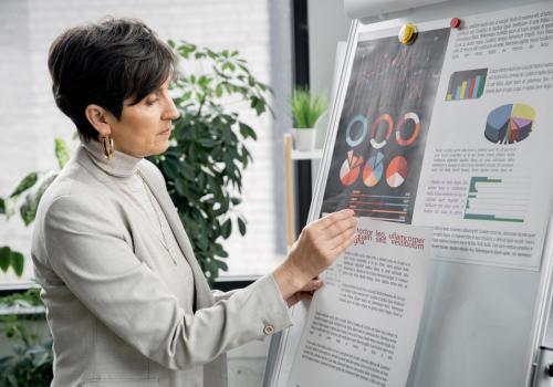 Mujer de perfil mirando gráficas en papel