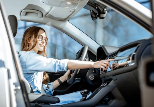 Mujer en el carro cambiando de estación de radio