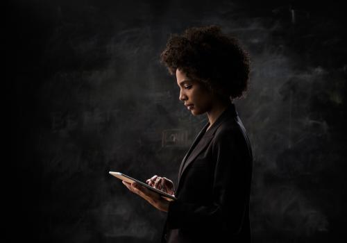 Mujer mirando computador con fondo negro