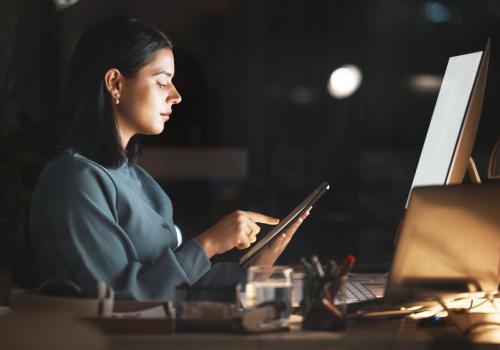 Mujer mirando una tablet en su escritorio