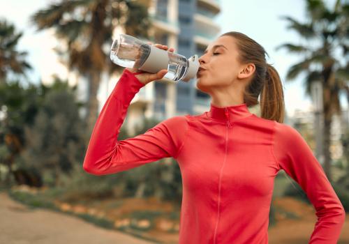 Mujer tomando agua de un termo