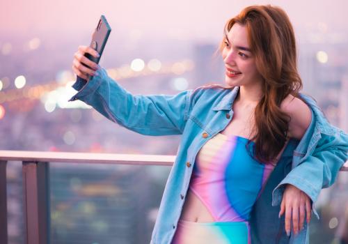 Mujer tomándose una fotografía con un fondo de ciudad