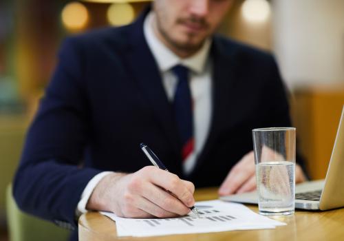 hombre escribiendo sobre un papel