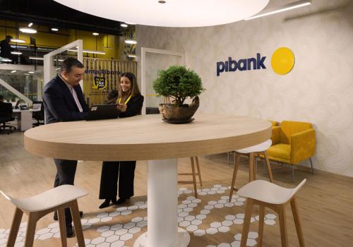 dos personas hablando en una oficina de Pibank