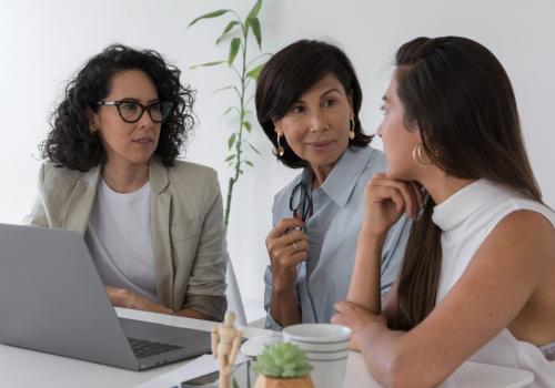 Tres mujeres hablando mientras se encuentran sentadas