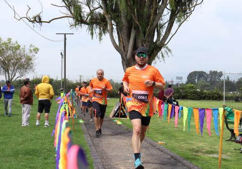 Foto de una persona corriendo en una maratón con una camiseta naranja