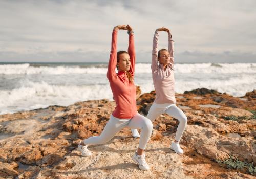 Dos mujeres haciendo deportes con la playa de fondo