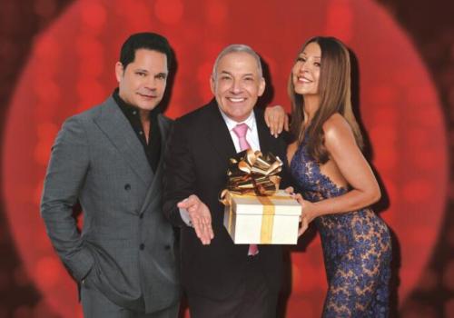 foto de una mujer y dos hombres posando con un regalo en sus manos