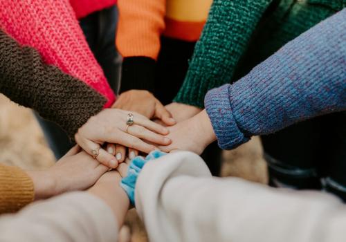 foto de varias personas poniendo su mano en el centro