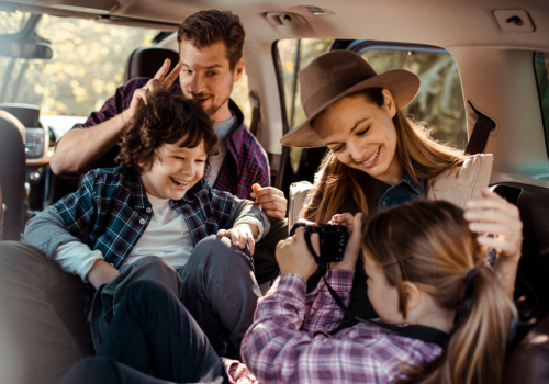 familia en un carro tomando fotografías