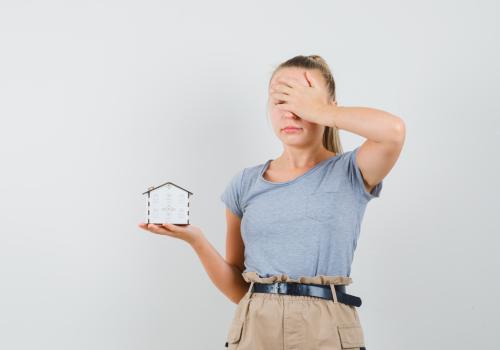 fotografía de una mujer sosteniendo un reloj y tapandose el rostro