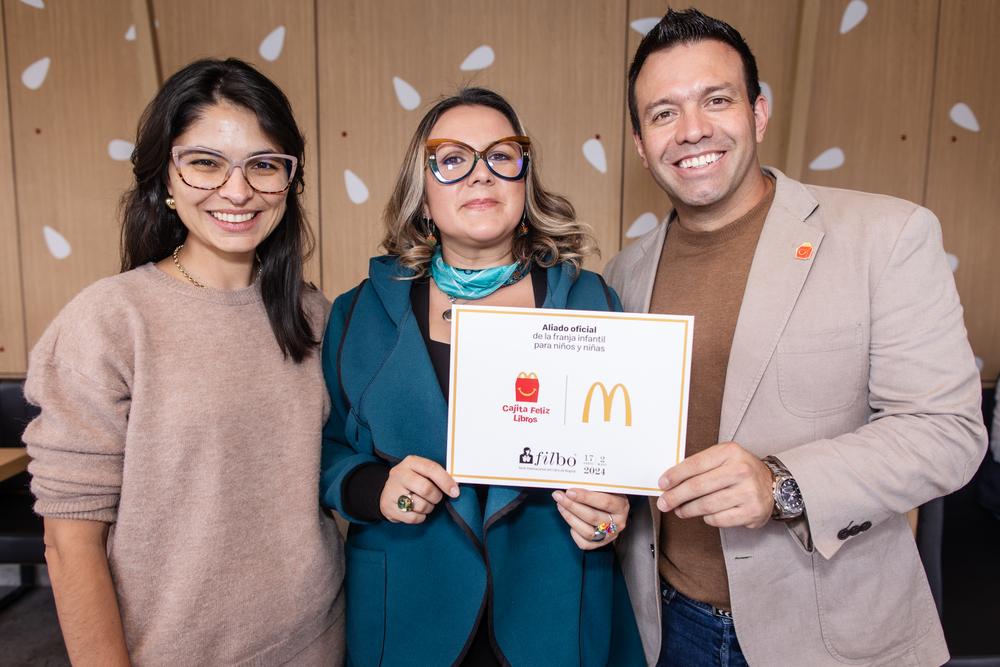 Foto de tres personas, dos mujeres y un hombre posando para la cámara