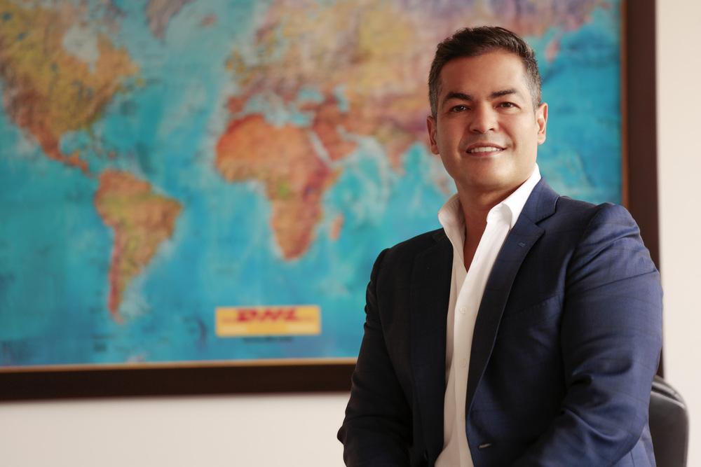 foto de un señor sonriendo a la cámara con un mapa de fondo