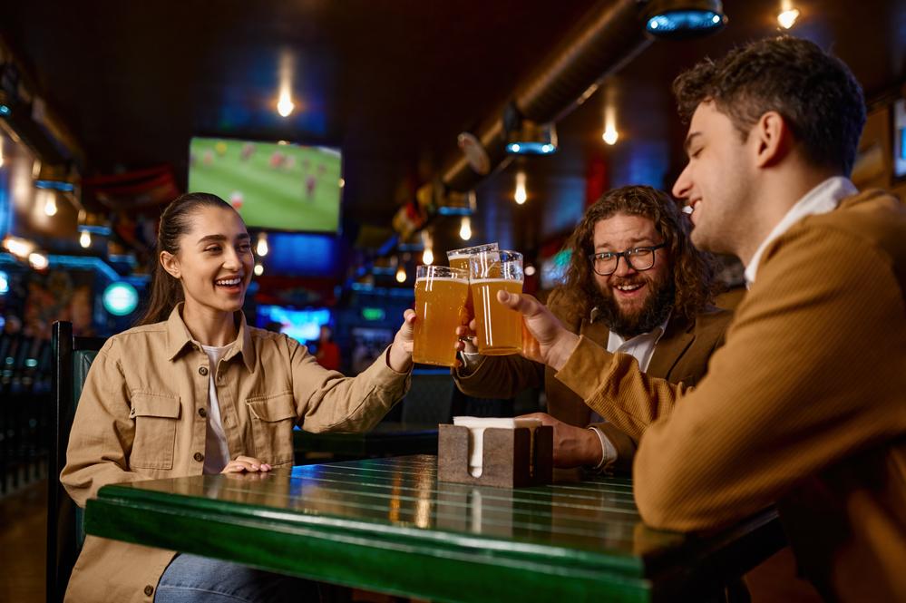 Amigos mirando un partido de futbol y tomando cerveza