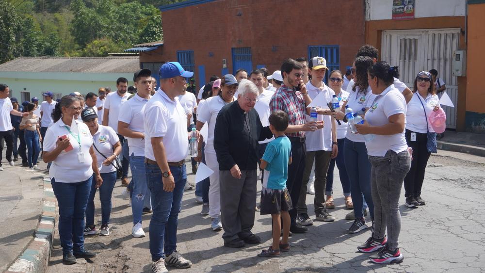 Foto de un cura con comunidad alrededor