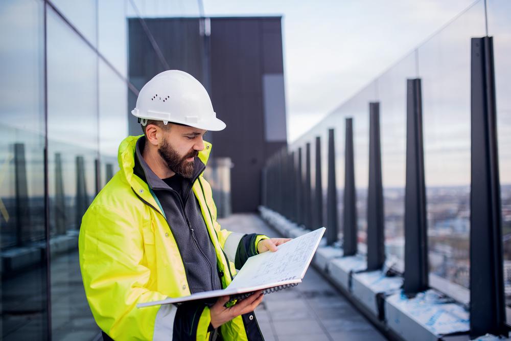 Constructor mirando planos en una terraza